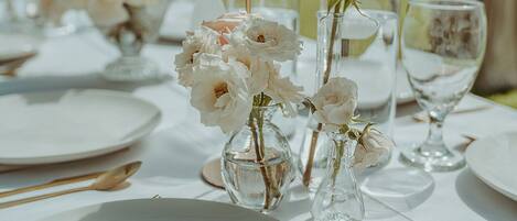 A table set for a meal with white plates, glasses, and cutlery.