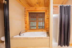 Un baño con detalles de madera, una bañera, un inodoro y una zona de ducha.