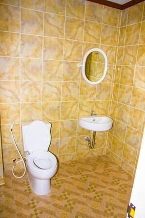 Ein Badezimmer mit Toilette, Waschbecken und Spiegel.