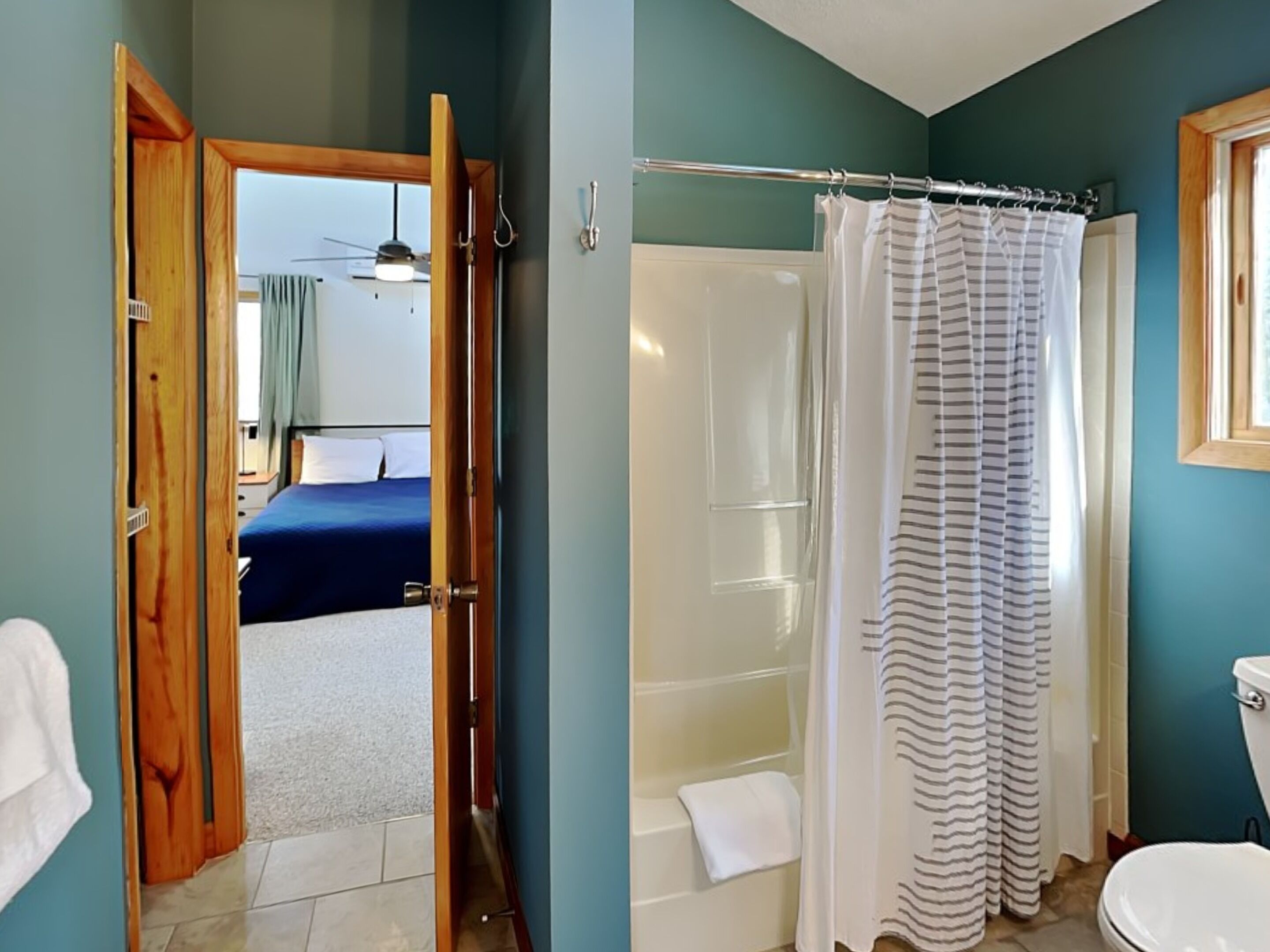 A bathroom with a shower, toilet, and a bathtub.