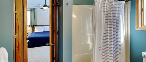 A bathroom with a shower, toilet, and a bathtub.