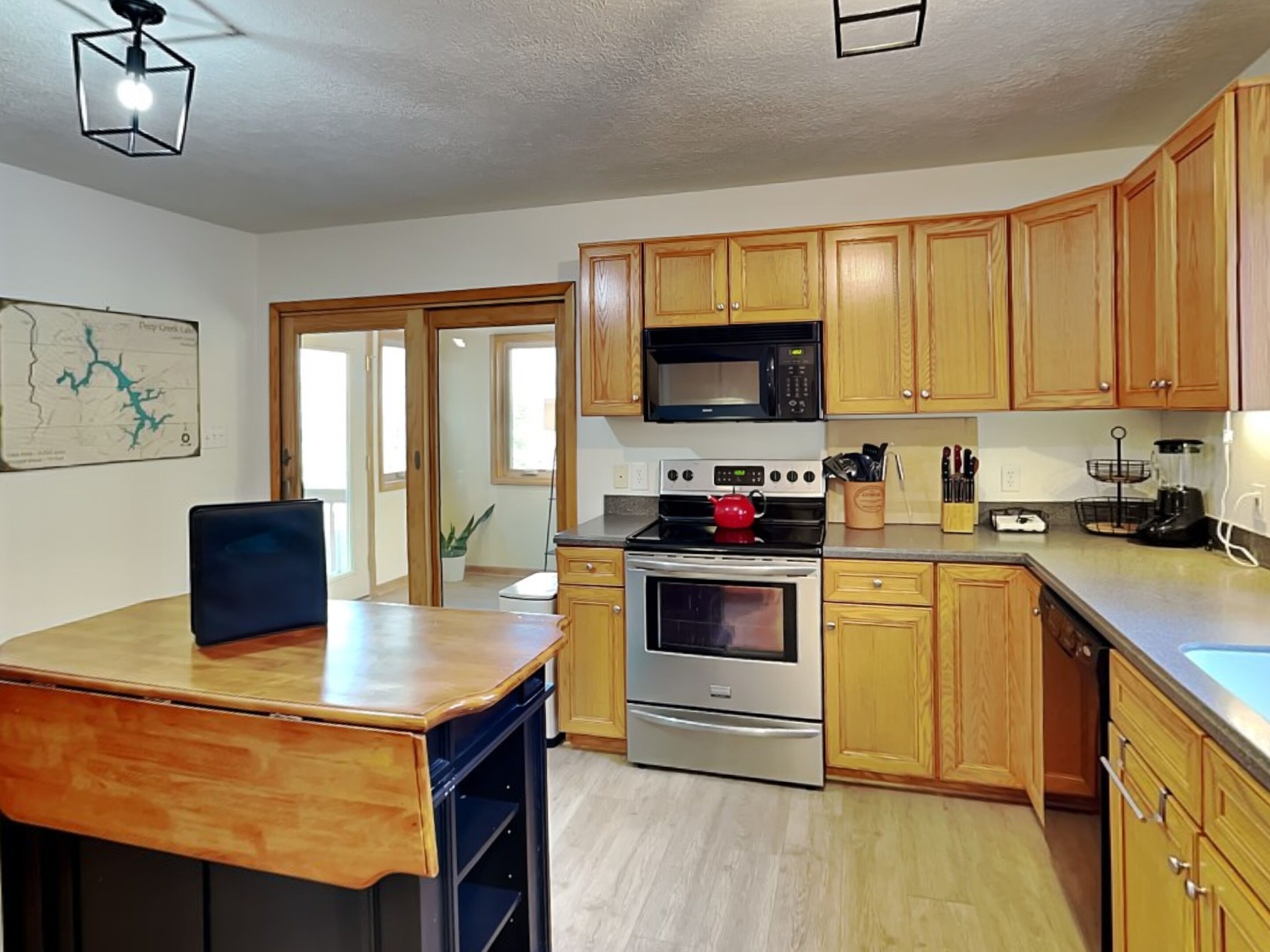 A kitchen with wooden cabinets, a microwave, an oven, and a sink.