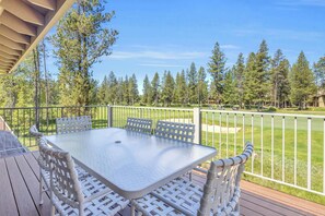 A deck with a table and chairs, surrounded by a white fence, overlooking a golf course. - Amazing view of golf course, hot tub, AC, pets ok (Sunriver)