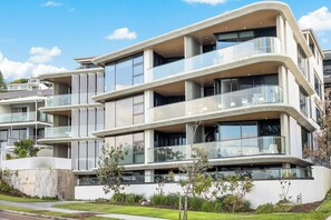 A multi-story residential building with balconies, large windows, and a modern architectural design. - Coolum First Bay 121 (Coolum Beach)