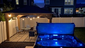 A backyard with a hot tub, patio furniture, and string lights. - Family Gathering Place 6 BD Home Hot Tub sleeps 12 (American Fork)