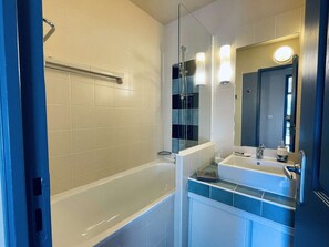 Bathtub, hair dryer, soap, toilet paper