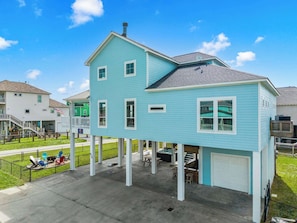 A two-story house with a garage, a covered patio, and a small outdoor seating area.
