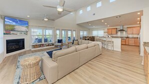 A spacious living area with a large sofa, a fireplace, and a ceiling fan. - 360* Views at "LGI Paradise" ~ Screened Porch w/ Hot Tub, Golf Cart included (Placida)