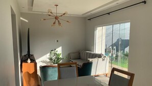 Ein Essbereich mit einem großen Tisch, Stühlen, einer Couch und einer Pflanze.