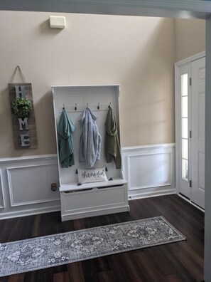 Welcome to a classic entryway with a cozy bench and decorative sign.