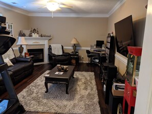 Cozy living room with a fireplace, comfortable seating, and a television.
