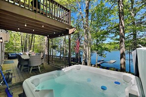 A hot tub on a wooden deck with a view of a lake and trees. - Bearfoot Lodge by Taylor Made Deep Creek (Oakland)