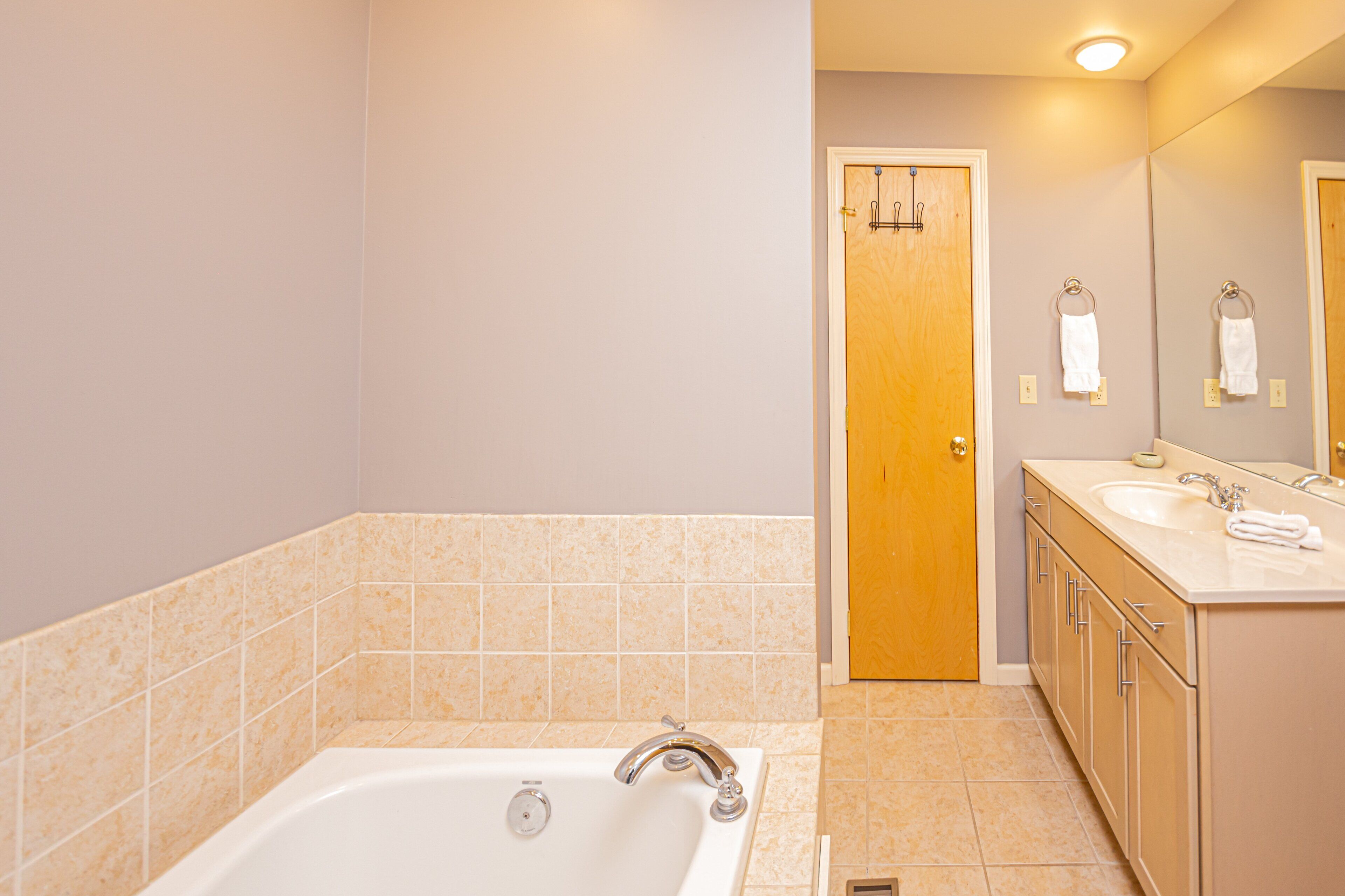 Un baño con bañera, lavamanos y espejo.