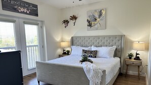 Ein Schlafzimmer mit einem großen Bett, zwei Nachttischen mit Lampen, einem Deckenventilator und einem Schild an der Wand.
