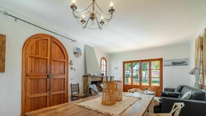 Ein Essbereich mit Holztisch, Stühlen, einer Deckenleuchte und einem Kamin.