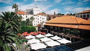 A rooftop bar with white umbrellas and palm trees. - Coogee Bay Hotel Pub Style (Sydney)