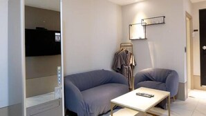 A modern hotel room with a sofa, a small table, and a wardrobe. - Hound Hotel Seomyeon-bumcheon (Busan)