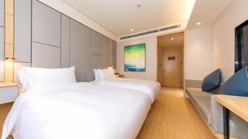 Quarto de hotel com uma cama grande, mesas de cabeceira, uma TV e um quadro na parede.