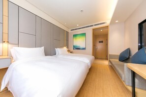 Une chambre d’hôtel avec un grand lit, des tables de chevet, une télévision et un tableau au mur.