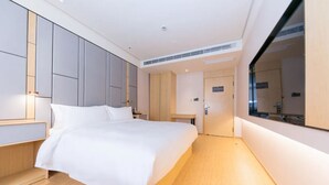 A modern hotel room with a large bed, built-in wardrobe, and a large mirror. - Ji Hotel Shanghai Stadium (Shanghai)