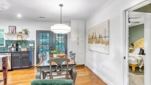 A modern kitchen with a dining area, wooden flooring, and a large window. - Modern and clean home, quick access to attractions (Atlanta)