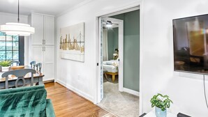 A modern living room with a dining area, a large window, and a view of a cityscape. - Modern and clean home, quick access to attractions (Atlanta)
