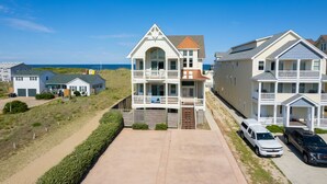 Un quartier résidentiel situé en bord de mer, avec des immeubles à plusieurs étages dotés de balcons et offrant une vue dégagée sur l’océan.