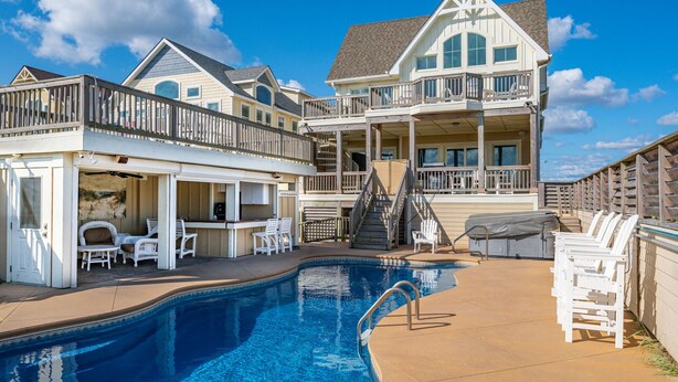 Une grande maison dotée d’une piscine, de plusieurs terrasses et d’espaces aménagés pour se détendre en plein air.