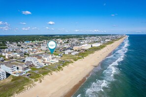 An aerial view of coastal Carolina with a beach, houses, and a clear sky. - Best of My Love:Oceanfront, heated pool, hot tub, elevator, rec and theater room (Kill Devil Hills)
