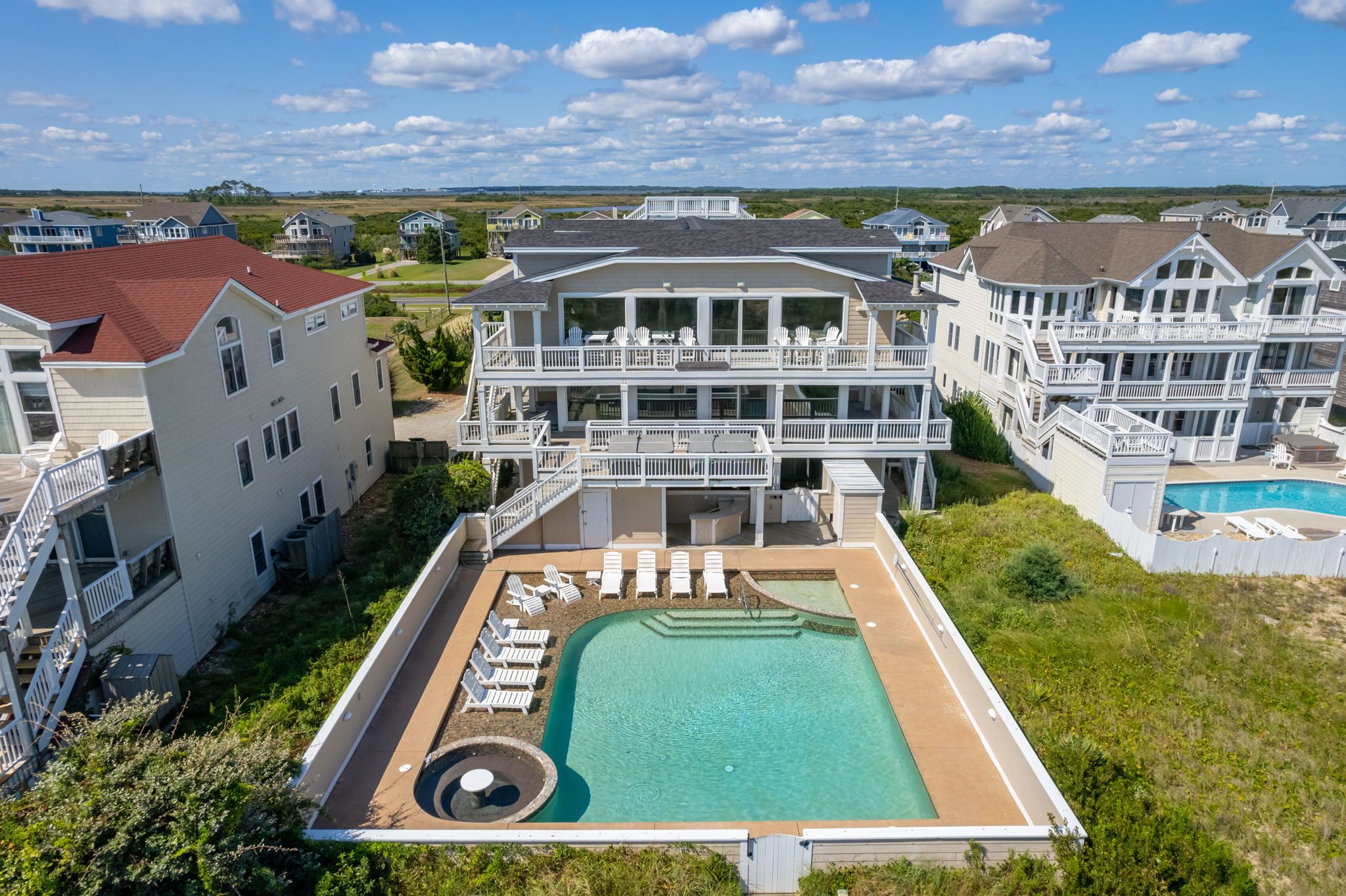 A large resort with multiple buildings, a swimming pool, and outdoor seating areas.