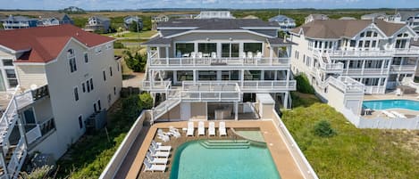 A large resort with multiple buildings, a swimming pool, and outdoor seating areas.