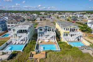 A coastal residential area with multiple two-story houses featuring balconies and swimming pools.