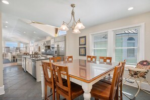 A spacious kitchen with a dining area, a ceiling fan, and a view of the outdoors.