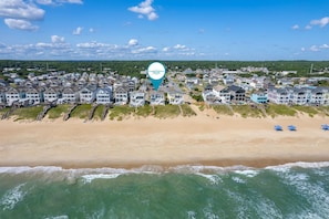 An aerial view of Coastal Carolina with beachfront houses, a sandy beach, and ocean waves.