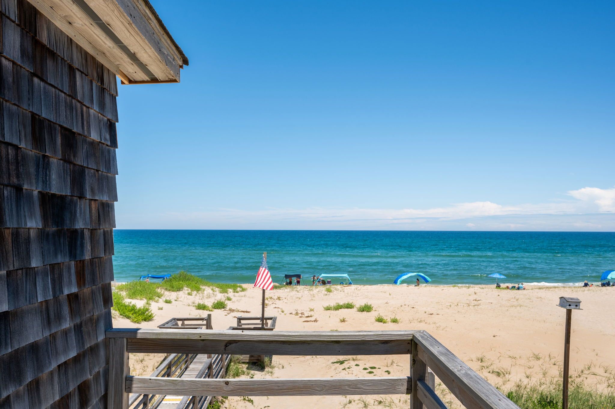 A wooden beach house with a view of the ocean.