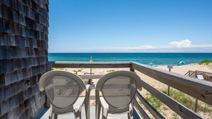A wooden deck with two chairs facing a beach. - Gillam Hall: Oceanfront, private walkway, tons of space and beautiful beaches. (Nags Head)