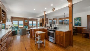 A spacious kitchen with wooden cabinets, a large island, and a view of the ocean. - Gillam Hall: Oceanfront, private walkway, tons of space and beautiful beaches. (Nags Head)