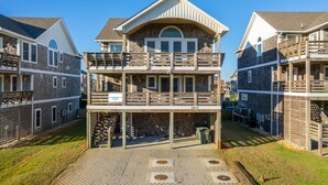 A multi-story building with a balcony on the second floor, a covered front porch, and a number "2612" on the front. - Phelps Brothers-Ocean Views, pool, hot tub, dog friendly, rec room & elevator! (Nags Head)