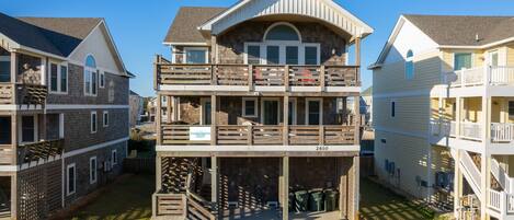 Un edificio residencial de varios pisos con un patio central, balcones y un letrero que indica 'Coastal Carolina'.