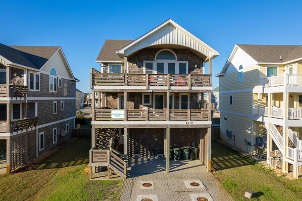 A multi-story residential building with a central balcony, a garage, and a sign indicating it is part of Coastal Carolina.