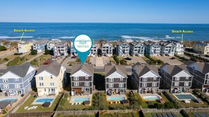 A coastal residential area with multiple houses, each with a pool. Beach access is indicated on both sides of the image. - Phelps Brothers Too:Ocean Views, Private pool, hot tub, elevator & Dog Friendly! (Nags Head)