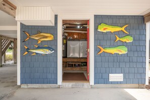 A building with a blue exterior and a door leading to a laundry area with a washing machine and dryer. - At Ease: Ocean views, short walk to the beach, close to fishing pier. (Nags Head)