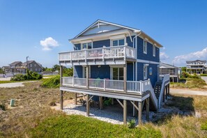 A two-story beachfront house with a balcony and a covered outdoor area. - At Ease: Ocean views, short walk to the beach, close to fishing pier. (Nags Head)