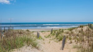 A beach with sand dunes and a wooden fence. - At Ease: Ocean views, short walk to the beach, close to fishing pier. (Nags Head)