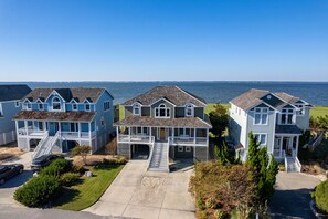 A coastal residential area with houses featuring front porches and a view of the sea.