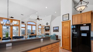 Una cocina amplia con armarios de madera, una isla grande y un refrigerador negro.