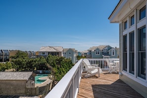 A residential area with houses, a wooden deck, and a swimming pool. - Piggy's Paradise-Oceanside, community pool, private hot tub, short walk to the beach! (Nags Head)