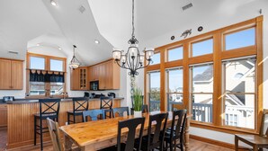 Una cocina amplia con armarios de madera, una isla central y ventanas grandes con vistas.