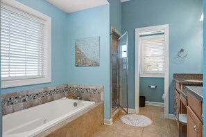 Une salle de bain avec une baignoire, une douche et un meuble-lavabo.