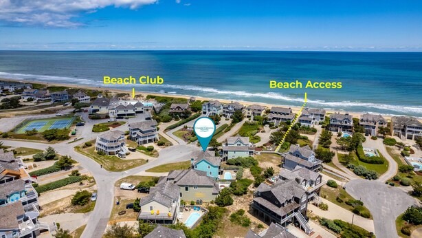 Vista aerea di una zona residenziale costiera con un beach club e accesso diretto alla spiaggia.